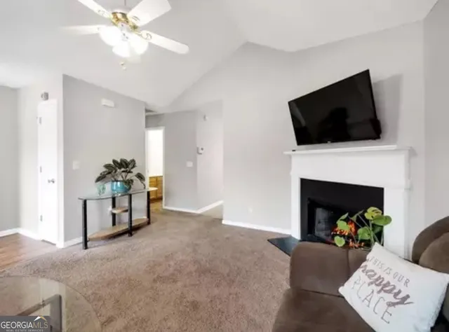 a living room with furniture a fireplace and a flat screen tv