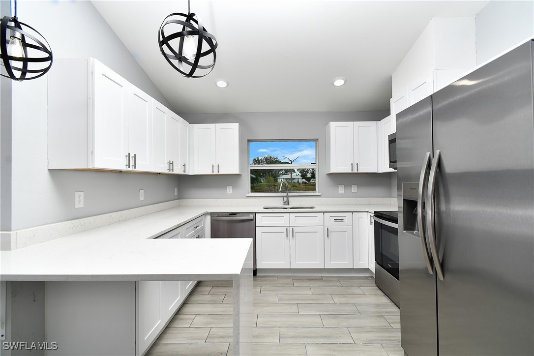 3103 Vera Avenue South Lehigh Acres, FL 33976 - Photo 17 of 36 a kitchen with a refrigerator a sink and cabinets