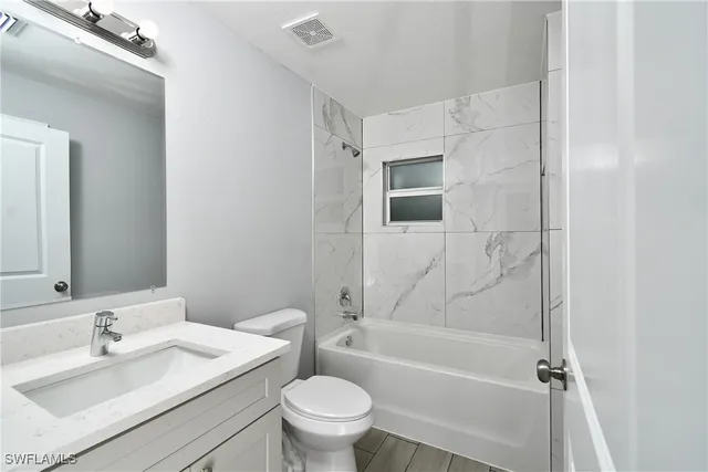 a bathroom with a sink toilet vanity and shower