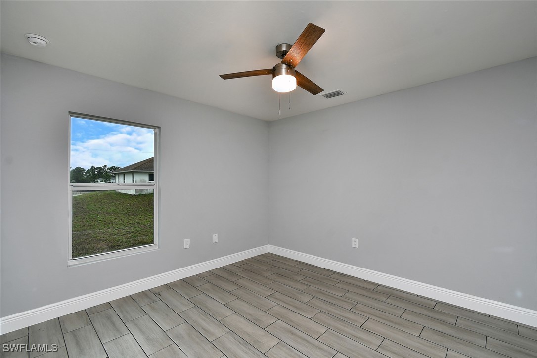 3103 Vera Avenue South Lehigh Acres, FL 33976 - Photo 24 of 36 wooden floor in an empty room with a window