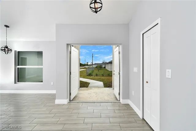 a view of a hallway with wooden floor and a living room