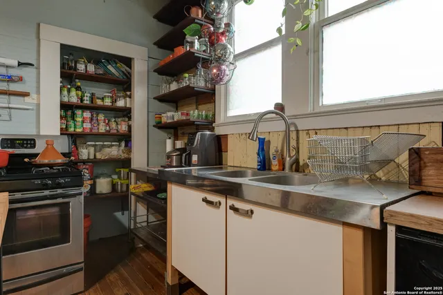a kitchen with stainless steel appliances granite countertop a sink and wooden cabinets