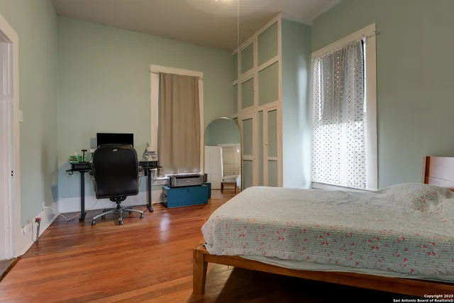 a view of a hallway with wooden floor and dining room view