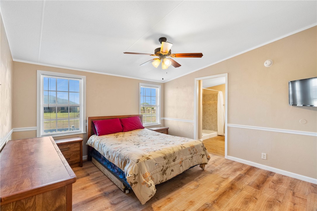 4752 Homestead Lane Robstown, TX 78380 - Photo 8 of 22 a bedroom with a large bed a chandelier and a window