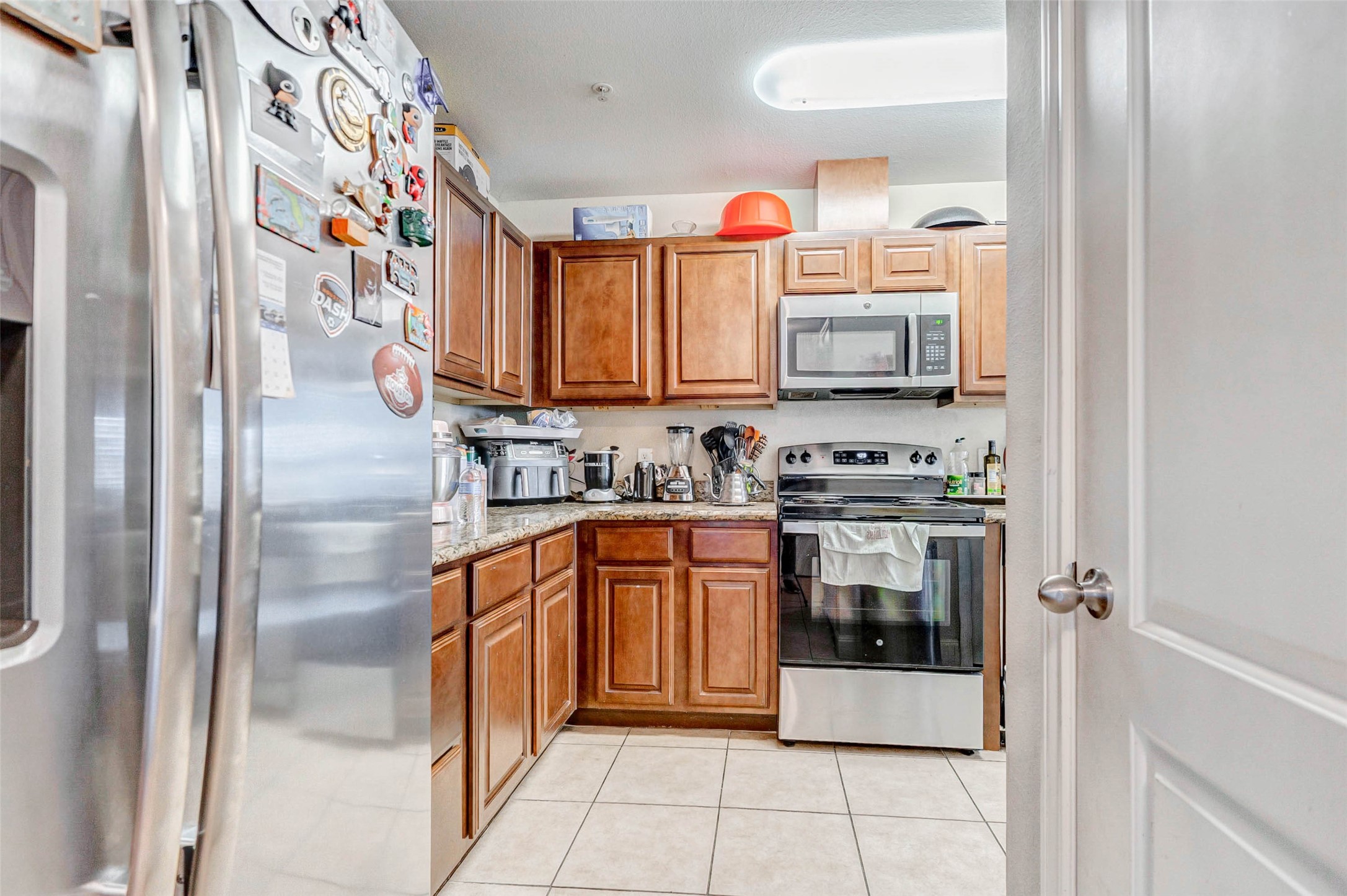 1702 Doyle Court, Unit 2 Pasadena, TX 77503 - Photo 13 of 30 a kitchen with stainless steel appliances granite countertop a stove a sink and a refrigerator