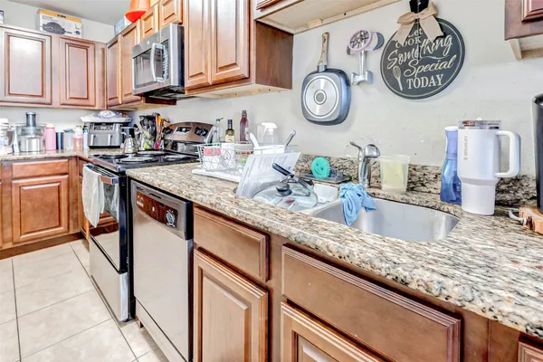 a kitchen with stainless steel appliances granite countertop a sink a stove top oven and dishwasher