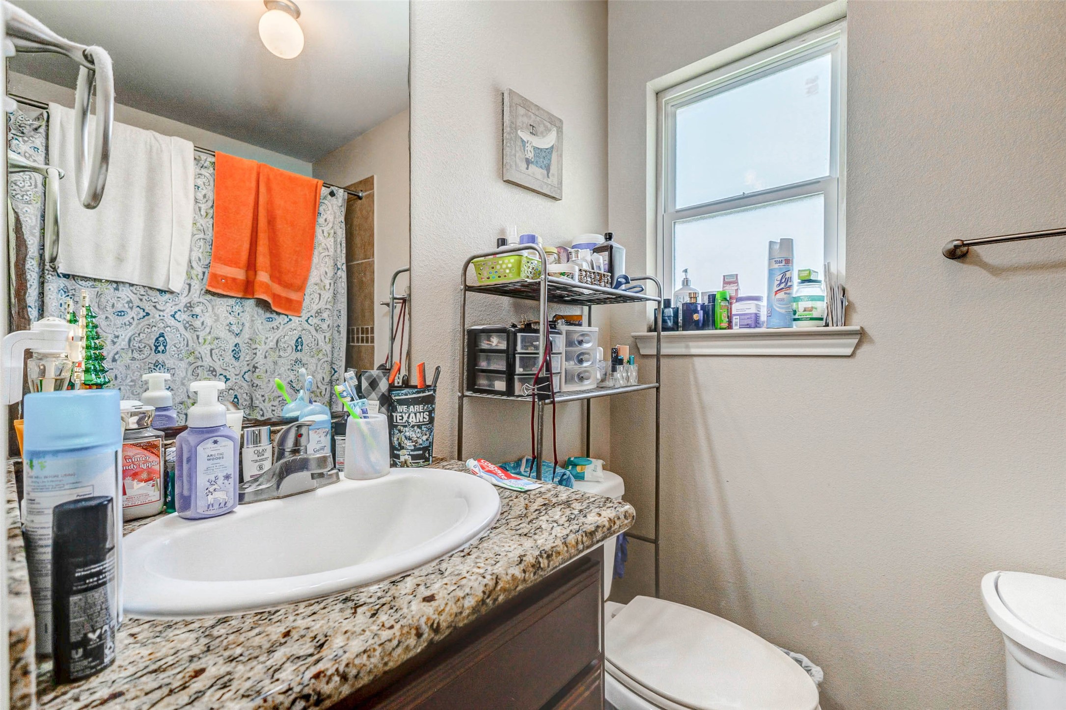 1702 Doyle Court, Unit 2 Pasadena, TX 77503 - Photo 22 of 30 a bathroom with a granite countertop sink a toilet and a mirror