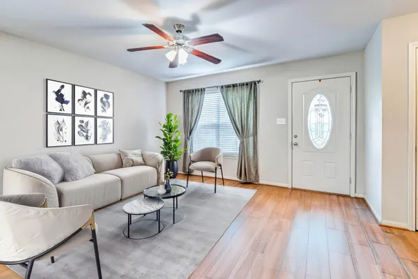 a living room with furniture a window and wooden floor