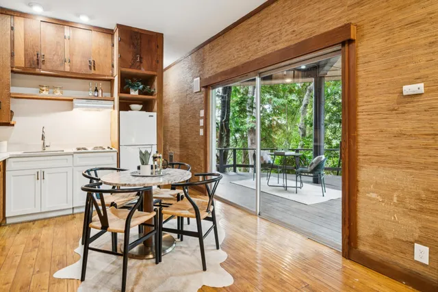 a bedroom with a balcony a bed and a large window