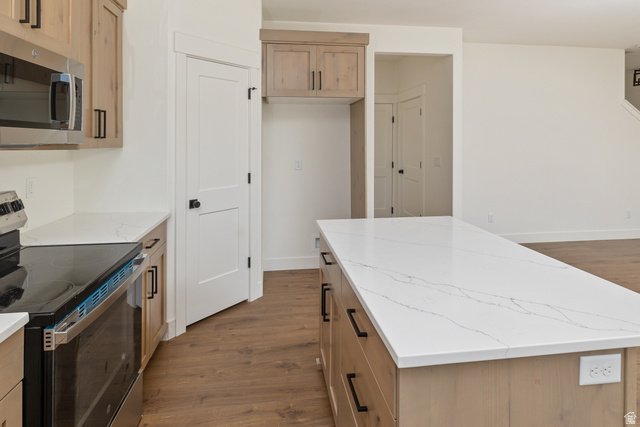 612 North 400 West Logan, UT 84321 - Photo 16 of 27 Kitchen featuring wood-finish cabinetry with black hardware, white countertops, stainless steel appliances, and wood-finish flooring