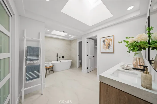 a white tub sitting next to a bathroom sink