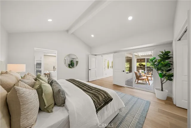 a bedroom with a balcony a large bed and a wooden floor