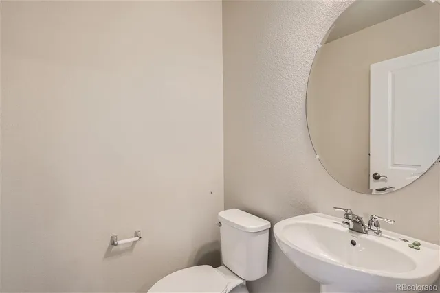 a bathroom with a sink mirror and toilet