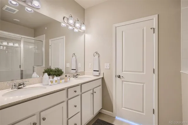 a bathroom with a double vanity sink and a mirror
