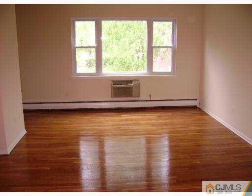 72 Fox Road, Unit 3B Edison, NJ 08817 - Photo 2 of 5 an empty room with wooden floor and windows