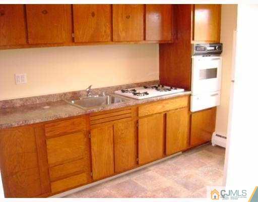 72 Fox Road, Unit 3B Edison, NJ 08817 - Photo 3 of 5 a kitchen with a stove and a cabinet