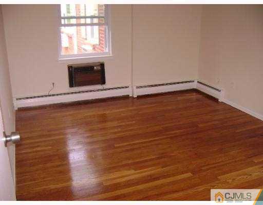 72 Fox Road, Unit 3B Edison, NJ 08817 - Photo 4 of 5 an empty room with wooden floor and windows