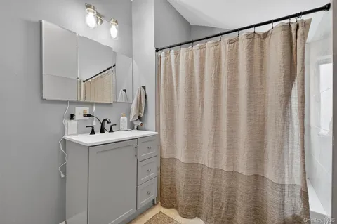a bathroom with a sink a mirror and a shower curtain