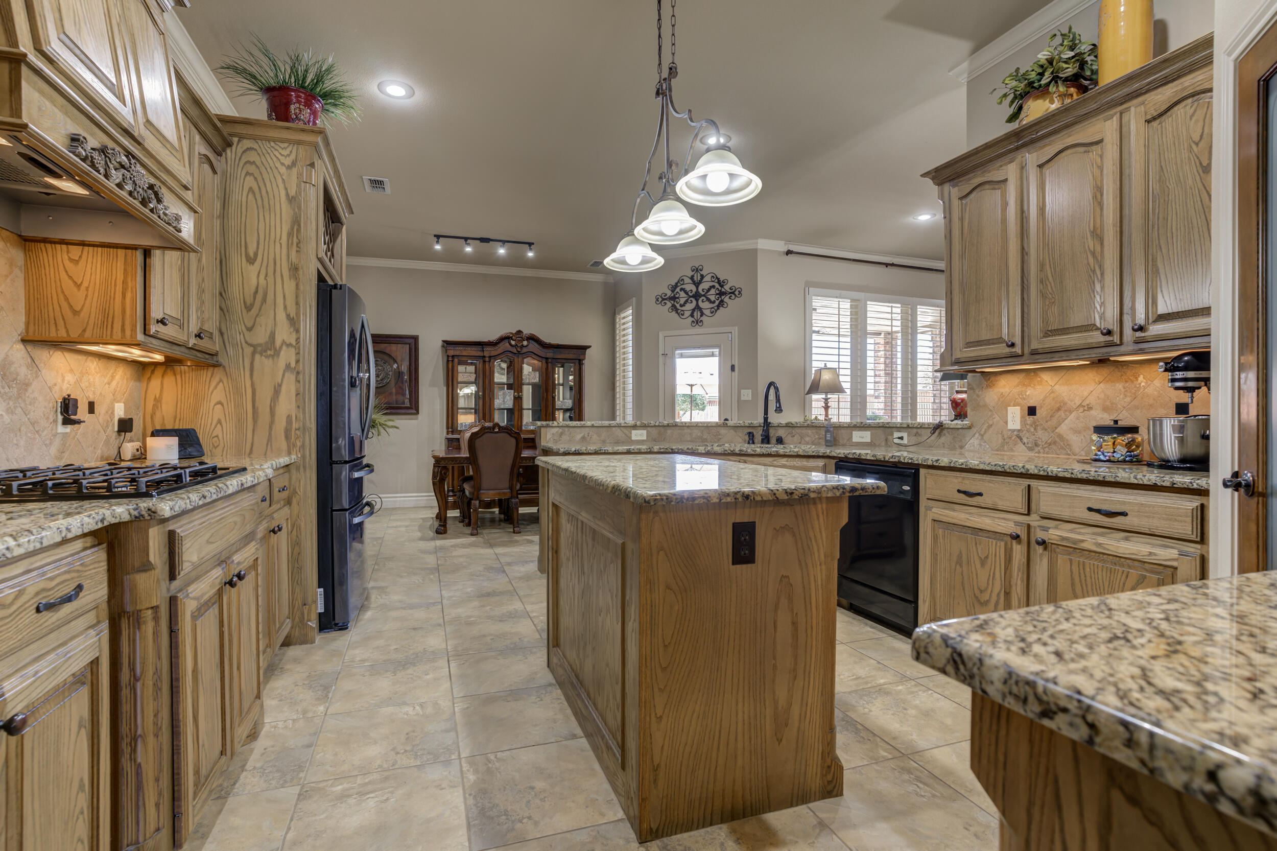 6008 89th Street Lubbock, TX 79424 - Photo 22 of 61 a kitchen with stainless steel appliances granite countertop a sink stove and refrigerator