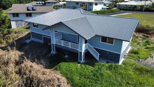 an aerial view of a house with garden space and street view