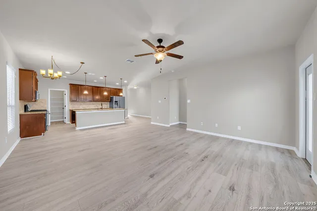 wooden floor in an empty room with a kitchen