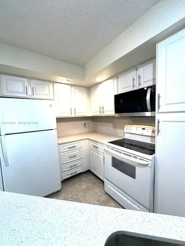 a kitchen with a sink appliances and cabinets