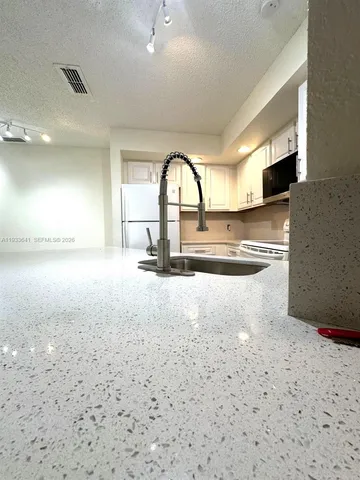 a view of a kitchen with a sink and cabinets
