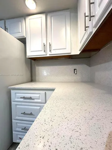 a view of kitchen cabinets and window