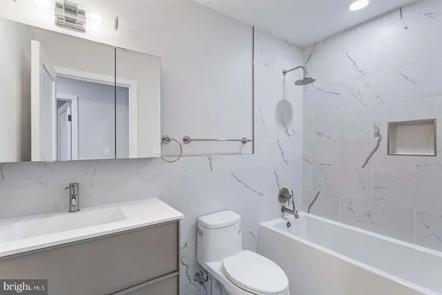 a bathroom with a sink toilet a mirror and shower