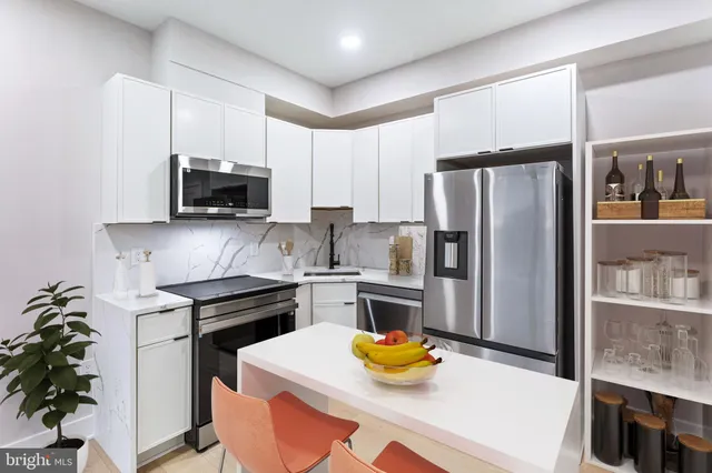 a kitchen with stainless steel appliances a sink a stove a refrigerator cabinets and a counter top space