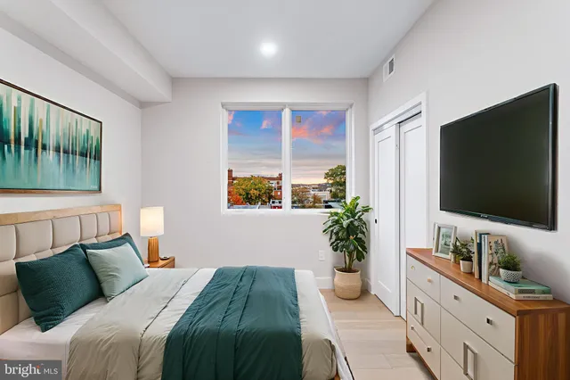 a bedroom with a balcony a bed and a flat screen television