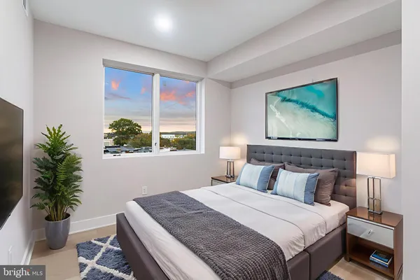 a bedroom with a large bed and a potted plant