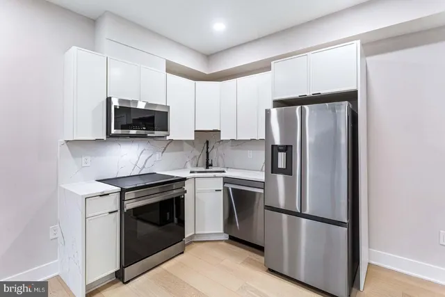 a kitchen with stainless steel appliances a refrigerator sink and microwave
