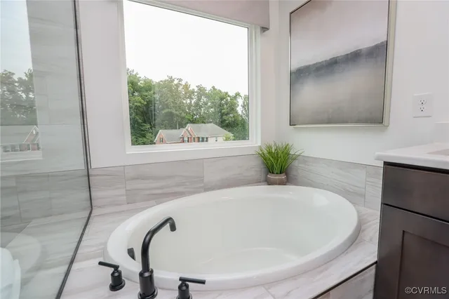 a bathroom with a tub shower and sink