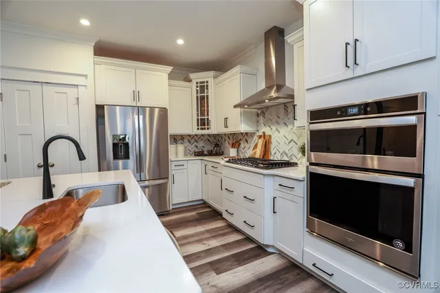 a kitchen with stainless steel appliances granite countertop a stove a sink and a refrigerator