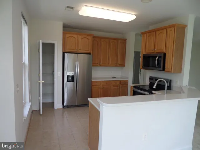 a kitchen with stainless steel appliances a stove a microwave a sink and cabinets