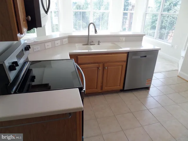a kitchen with stainless steel appliances a stove a sink and a microwave
