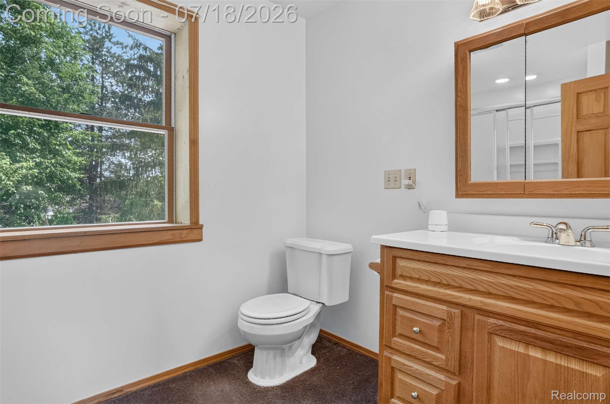1437 East Cook Road Grand Blanc, MI 48439 - Photo 63 of 69 Bathroom featuring a wood-framed window, a white toilet, and a vanity with wood-finish cabinetry, a white countertop, and a mirrored medicine cabinet