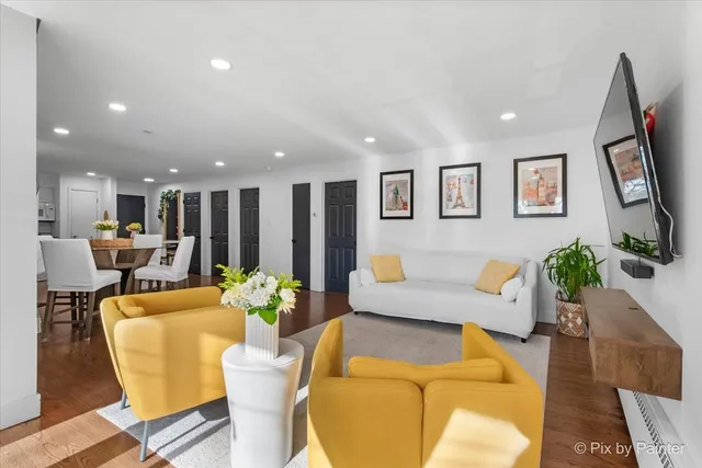 a living room with furniture kitchen view and a potted plant