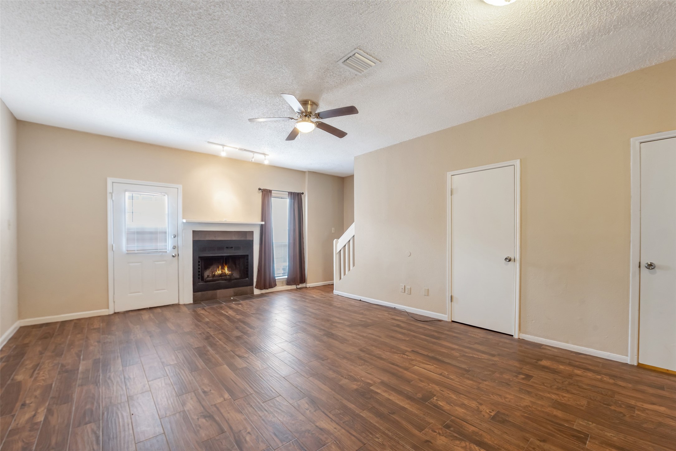 12400 Brookglade Circle, Unit 15 Houston, TX 77099 - Photo 12 of 43 an empty room with wooden floor fireplace and windows