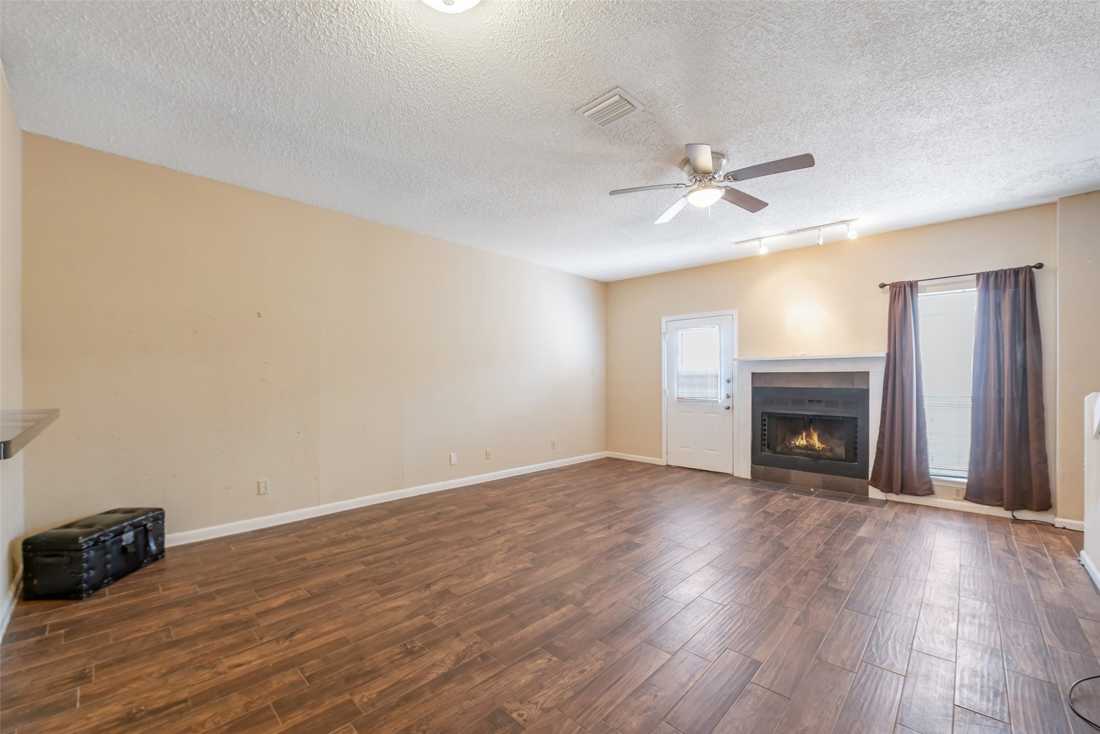 12400 Brookglade Circle, Unit 15 Houston, TX 77099 - Photo 14 of 43 a view of an empty room with wooden floor fireplace and a window