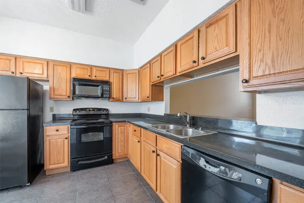 a kitchen with stainless steel appliances granite countertop a refrigerator and a stove top oven
