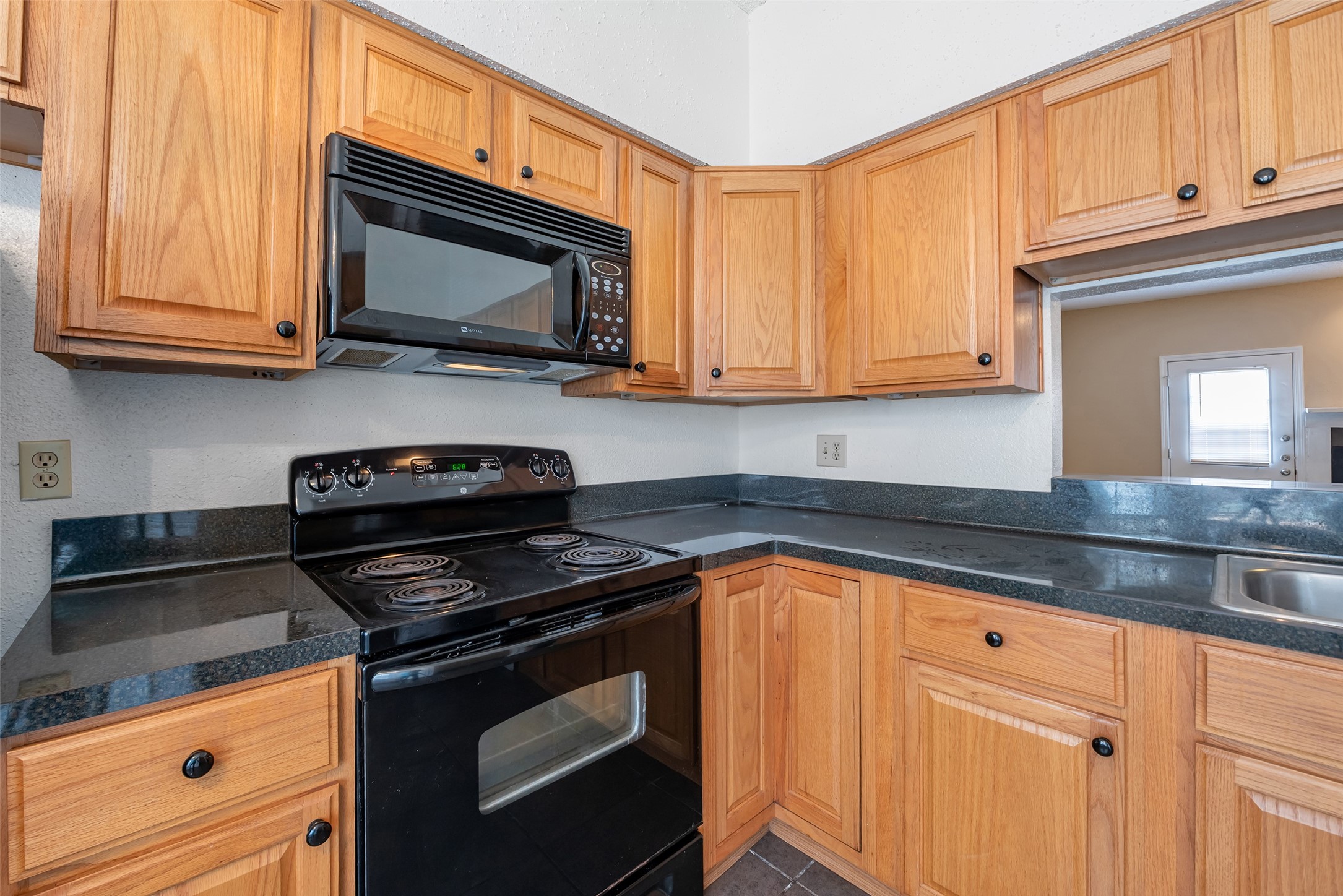 12400 Brookglade Circle, Unit 15 Houston, TX 77099 - Photo 17 of 43 a kitchen with granite countertop wood cabinets and stainless steel appliances