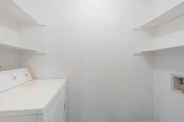 a view of a house with brick walls and a yard with plants