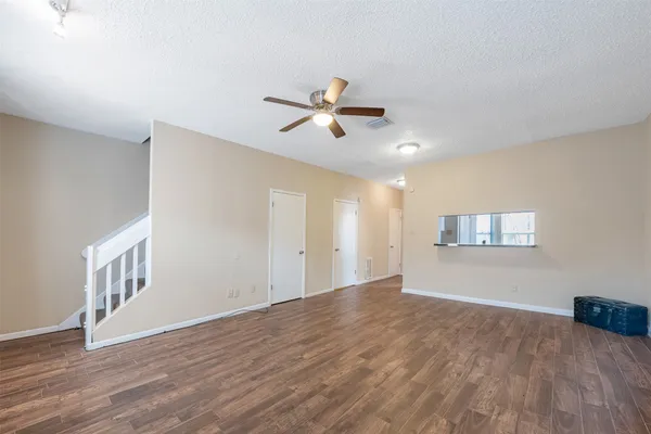 a view of empty room with wooden floor