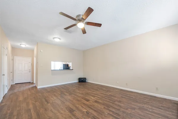 an empty room with wooden floor fireplace and windows