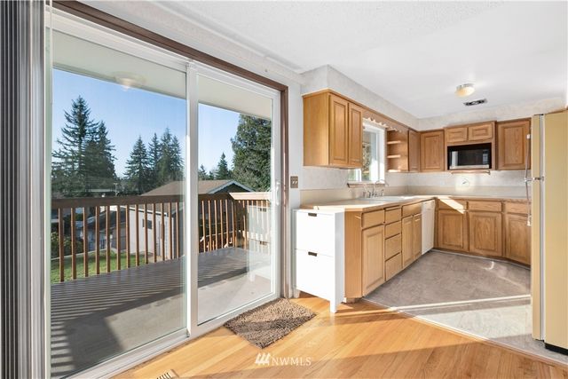 a kitchen with a sink cabinets appliances and a large window