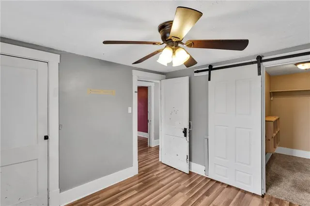 a view of a hallway with wooden floor and cabinet