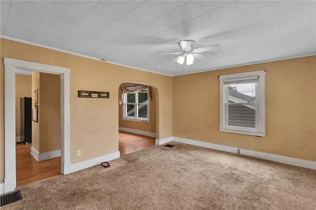 an empty room with windows and fan