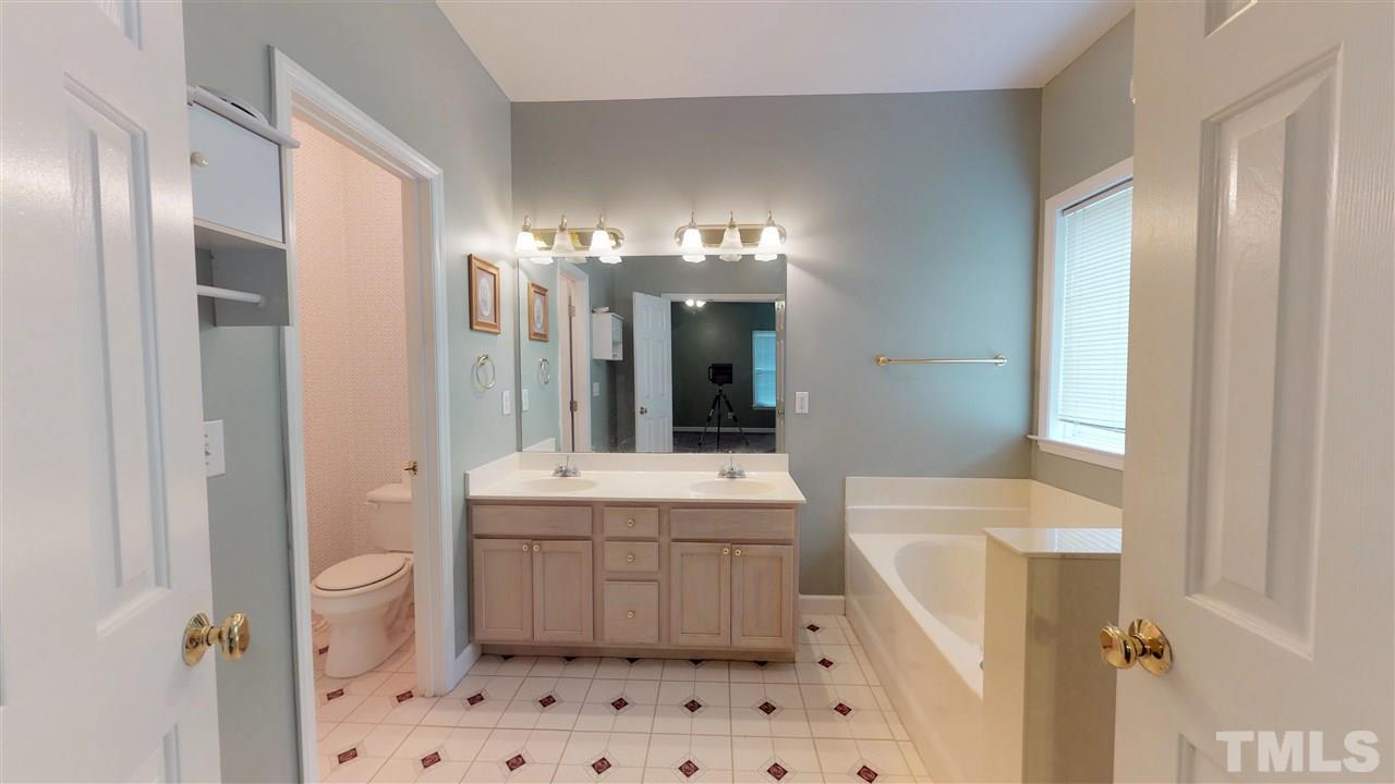 3517 Dewing Drive Raleigh, NC 27616 - Photo 22 of 25 a bathroom with a sink a toilet a mirror and shower